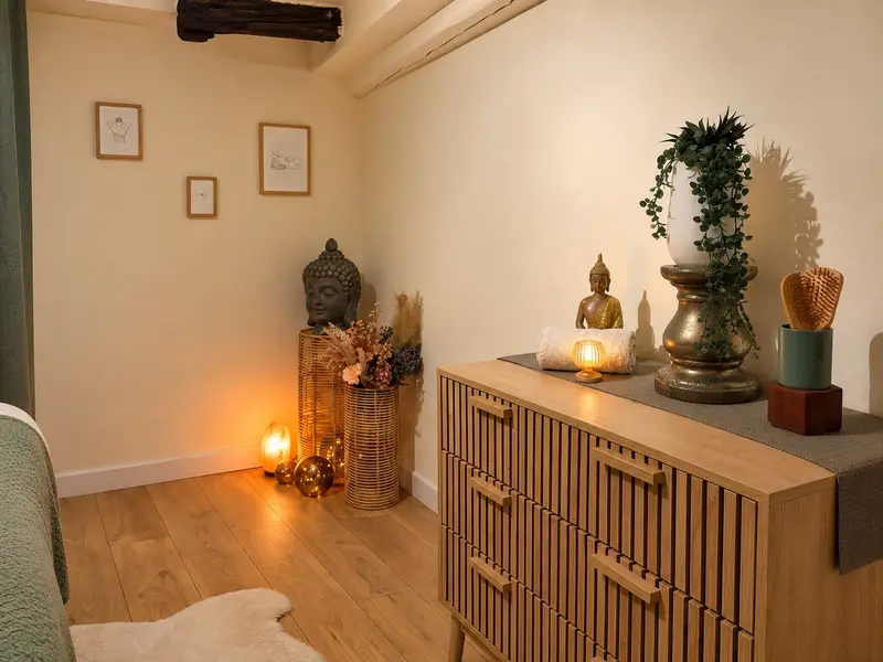 Commode en bois, bouddha, plante et bougies dans la cabine